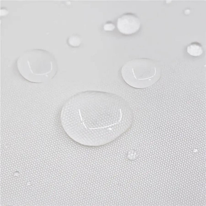 Close-up of water droplets beading on a white waterproof liner fabric.